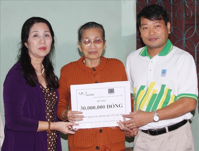 Đại diện Liên đoàn Lao động tỉnh Quảng Trị và Quỹ từ thiện xã hội Tấm lòng Vàng (Báo Lao động) trao số tiền hỗ trợ cho bà Trần Thị Giỏ, trú tại thành phố Đông Hà, là mẹ của liệt sỹ Tống Sỹ Bái hy sinh trong trận chiến đấu bảo vệ Gạc Ma. Ảnh: Hồ Cầu - TTXVN