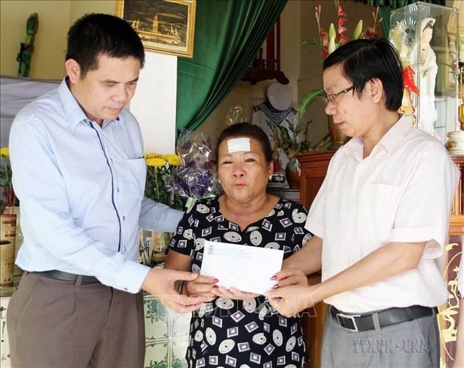 Đại diện Liên đoàn Lao động tỉnh Quảng Trị và Quỹ từ thiện xã hội Tấm lòng Vàng (Báo Lao Động) trao tiền hỗ trợ cho bà Nguyễn Thị Hằng, ở thành phố Đông Hà, tỉnh Quảng Trị, là mẹ liệt sĩ Hoàng Ánh Đông hy sinh trong trận chiến đấu bảo vệ Gạc Ma năm 1988. Ảnh: Hồ Cầu - TTXVN