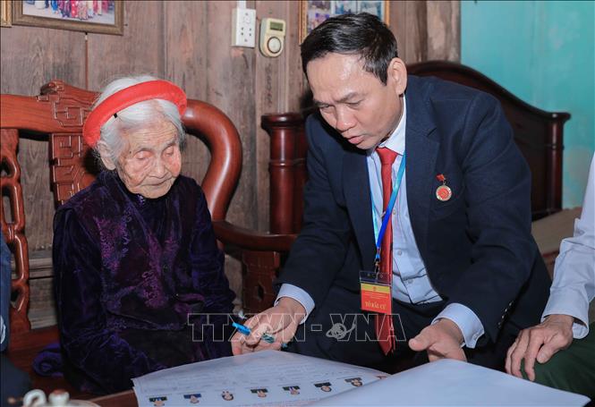 Cán bộ phường Phúc Lợi trực tiếp hỗ trợ, giới thiệu danh sách người ứng cử cho cử tri Chu Thị Nhớn, 102 tuổi, cử tri cao tuổi thuộc Bet88.Com Link Nhà Cái Bet88 BMXCT Uy Tín có công với cách mạng. Ảnh: Phan Phương – TTXVN