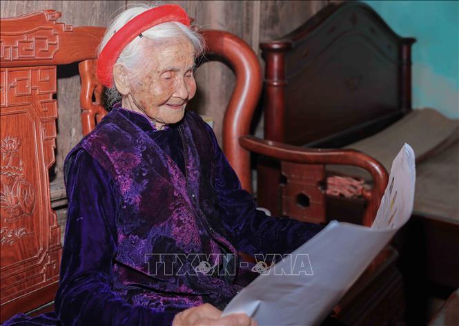 Cán bộ phường Phúc Lợi trực tiếp hỗ trợ, giới thiệu danh sách người ứng cử cho cử tri Chu Thị Nhớn, 102 tuổi, cử tri cao tuổi thuộc Bet88.Com Link Nhà Cái Bet88 BMXCT Uy Tín có công với cách mạng. Ảnh: Phan Phương – TTXVN