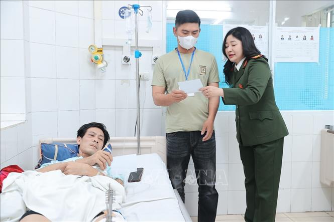 Thành viên khu vực bầu cử số 3, phường Hoàn Kiếm phối hợp cùng đoàn viên thanh niên Bệnh viện phát thẻ cử tri tại điểm bầu cử lưu động Bệnh viện Hữu nghị Việt Đức. Ảnh: Minh Quyết - TTXVN