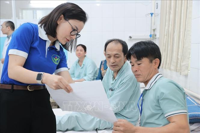 Đoàn viên thanh niên Bệnh viện Việt Đức hướng dẫn người nhà Bet88com casino, thể thao, bắn cá, nổ hũ và Bet88com casino, thể thao, bắn cá, nổ hũ về quy định bầu cử tại điểm bầu cử lưu động Bệnh viện Hữu nghị Việt Đức. Ảnh: Minh Quyết - TTXVN