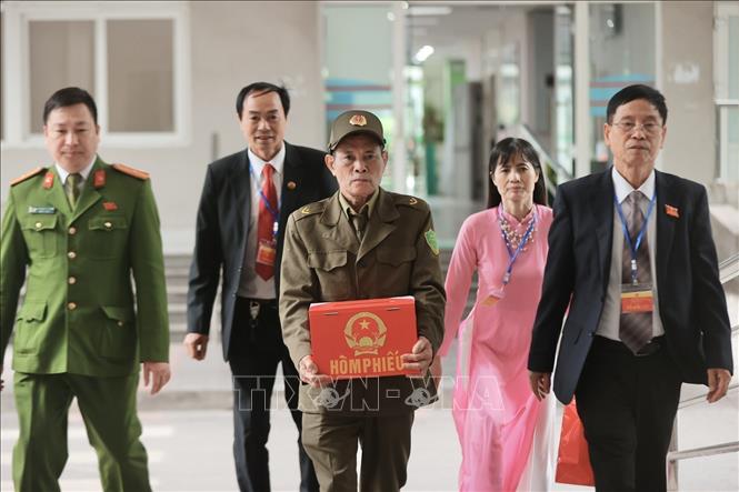 Thành viên tổ bầu cử số 5 phường Việt Hưng mang hòm phiếu đến điểm bầu cử lưu động Bệnh viện đa khoa Đức Giang chiều 15/3. Ảnh: Minh Quyết - TTXVN