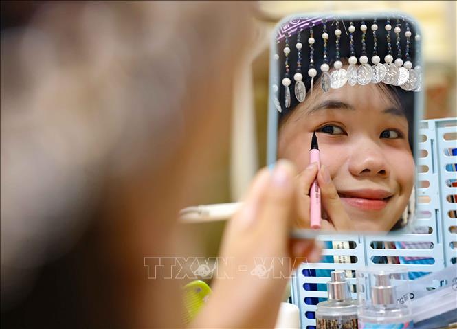 Không giấu nổi sự háo hức, các bạn đã thức dậy từ rất sớm, trang điểm nhẹ nhàng và chọn những bộ trang phục đẹp nhất để tham gia Ngày hội lớn. Ảnh: Thanh Tùng - TTXVN 