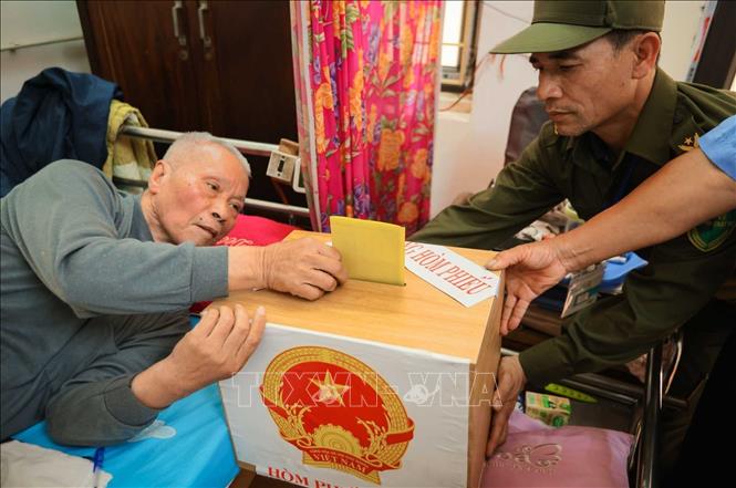 Cử tri Đỗ Văn Thế (sinh năm 1944, thương binh hạng ¼, tỷ lệ thương tật 91%) thực hiện bỏ phiếu vào hòm phiếu phụ. Ảnh: Hoàng Hiếu - TTXVN