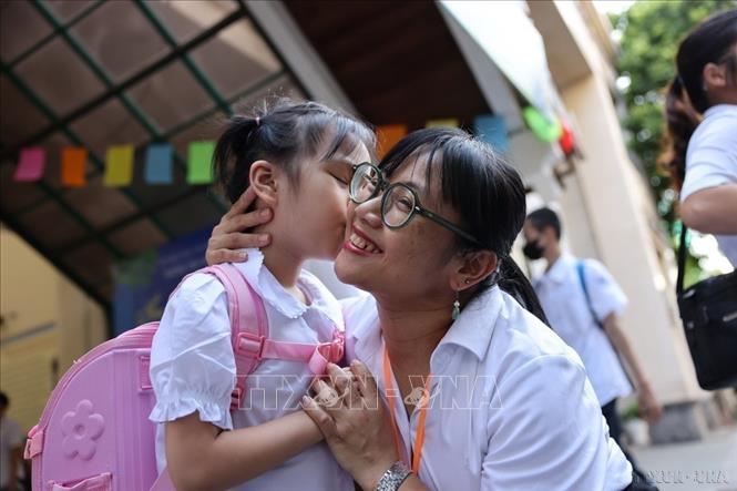 Cô giáo trường Tiểu học Bình Minh (Hoàn Kiếm, Hà Nội) vui mừng đón các em học sinh trong ngày khai giảng năm học mới 2024 - 2025. Ảnh: Thanh Tùng - TTXVN