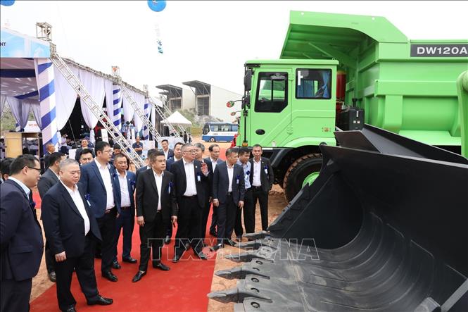 Lãnh đạo 2 tập đoàn cùng các đại biểu tham quan lô thiết bị, xe máy công trình chạy điện 100% đầu tiên được bàn giao. Ảnh: Đức Phương - TTXVN