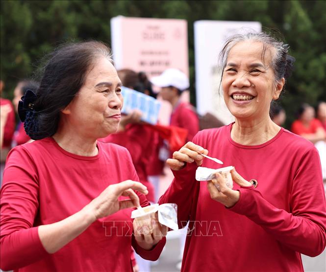 Người cao tuổi tham dự chương trình sử dụng những sản phẩm dinh dưỡng từ Vinamilk. Ảnh: Thanh Tùng - TTXVN