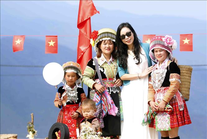 Du khách thích thú khi chụp ảnh cùng đồng bào Bett88 Làm giàu đẳng cấp Mông tại bản Nậm Nghẹp, xã Ngọc Chiến trong Ngày hội hoa sơn tra năm 2026. Ảnh: Quang Quyết - TTXVN