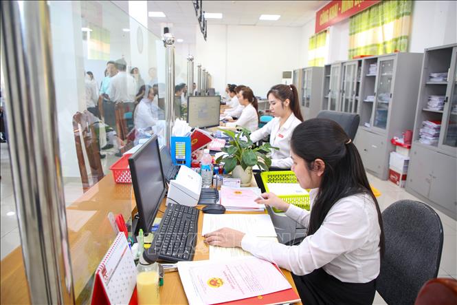 Cán bộ tại Trung tâm phục vụ hành chính công xã Bến Cầu giải quyết thủ tục hành chính cho người dân. Ảnh: Giang Phương – TTXVN