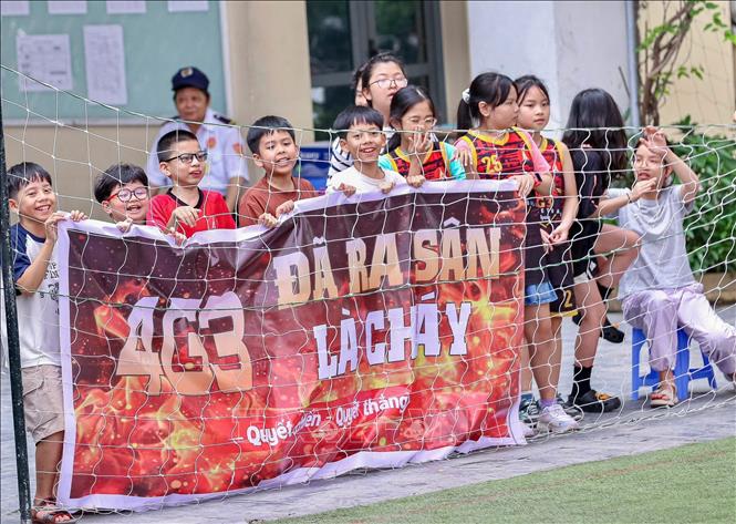 Các bạn nam lớp 5P4 nhiệt tình cổ vũ cho đội bóng rổ nữ của lớp mình thi đấu thật tốt. Ảnh: Hà Anh/TTXVN phát