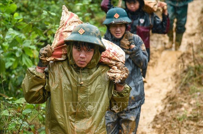 Cán bộ, chiến sỹ Ban Chỉ huy Phòng thủ Khu vực 5 Điện Bàn, Bộ Chỉ huy Quân sự thành phố Đà Nẵng vận chuyển vật liệu vào các khu vực khó khăn để xây dựng nhà cho người dân, quyết tâm hoàn thành thắng lợi “Chiến dịch Quang Trung”. Ảnh: Quốc Dũng – TTXVN