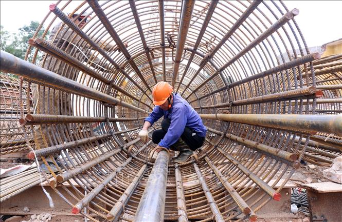 Công nhân thi công trụ sắt cọc khoan nhồi trên cạn phía đường Ngô Gia tự. Ảnh: Quốc Khánh - TTXVN