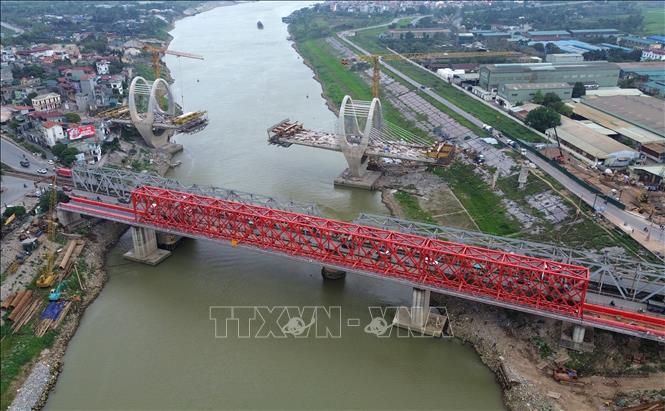 Bên cạnh đó cầu đường sắt (màu đỏ) bắc qua sông Đuống cũng được nhà thầu thi công khẩn trương. Sau khi hoàn thành đường bộ và đường sắt qua sông Đuống tách bạch. Ảnh: Quốc Khánh - TTXVN