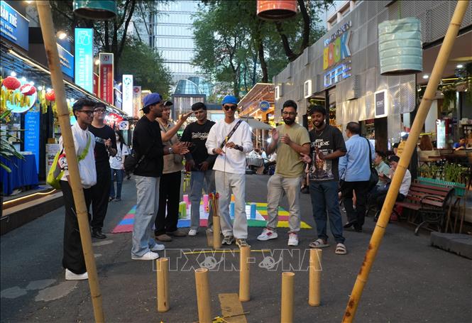 Một nhóm du khách đến từ Ấn Độ thích thú trải nghiệm các trò chơi dân gian trong không gian ngày hội. Ảnh: Hữu Duyên - TTXVN