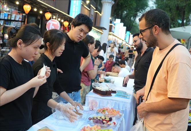 Du khách nước ngoài đặc biệt bị hấp dẫn bới các gian hàng giới thiệu các món bánh dân gian truyền thống của Việt Nam. Ảnh: Hữu Duyên - TTXVN