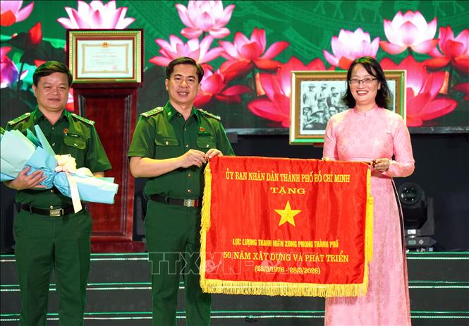 Bà Nguyễn Thị Diệu Thúy, Phó Chủ tịch UBND TP. Hồ Chí Minh trao tặng Cờ truyền thống của Chủ tịch UBND Thành phố tới Lực lượng Thanh niên xung phong. Ảnh: Trung Tuyến - TTXVN