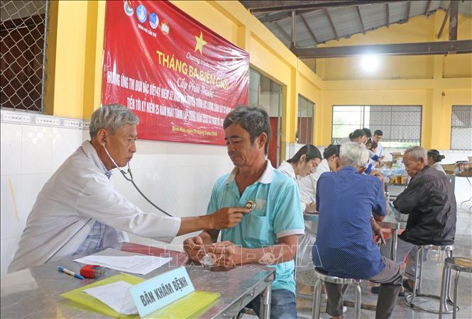 Các y bác sĩ Trường Cao đẳng Y tế Cần Thơ và các đơn vị đồng hành  khám, tư vấn sức khoẻ miễn phí người dân có hoàn cảnh khó khăn trên địa bàn xã Bình Hoà, tỉnh An Giang. Ảnh: Công Mạo-TTXVN