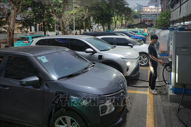 Người dân tranh thủ sạc phương tiện tại các điểm công cộng. Ảnh: Phạm Tuấn Anh - TTXVN