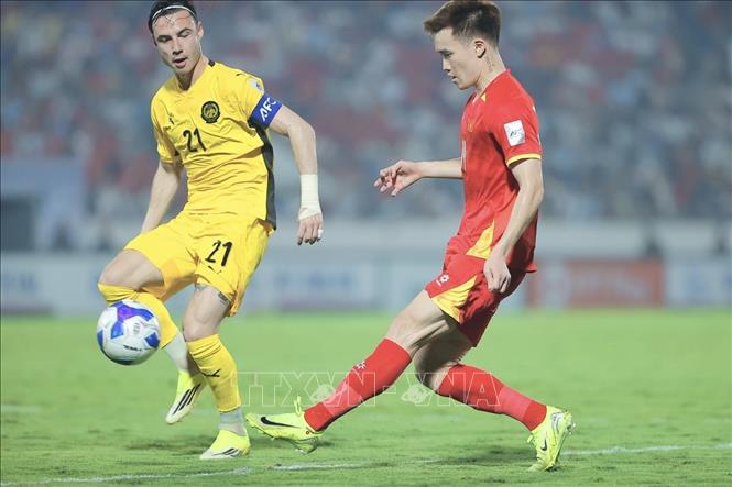 Hoàng Đức (14) thi đấu xuất sắc và chỉ thiếu chút may mắn để có bàn thắng khi pha dứt điểm đẳng cấp của anh trong hiệp 1 đã đánh bại thủ môn Malaysia nhưng bị cột dọc từ chối. Ảnh: Minh Quyết - TTXVN