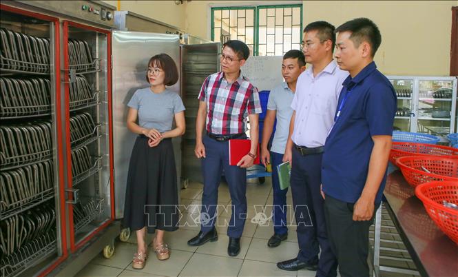 Đoàn kiểm tra của phường Nam Định kiểm tra tủ sấy khay, chén bát tại Trường Tiểu học Chu Văn An. Ảnh: Công Luật - TTXVN