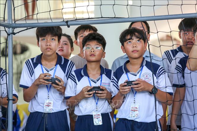 Các em học sinh trực tiếp thao tác, làm quen với thiết bị công nghệ hiện đại trong hoạt động trải nghiệm. Ảnh: Giang Phương - TTXVN 