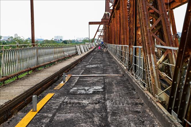Mặt cầu tại Cầu Long Biên được cào bóc lớp cũ, đồng thời hệ thống máng thoát nước cũ cũng được tháo dỡ để thay thế bằng hệ thống mới. Ảnh: Vân Chi/TTXVN phát