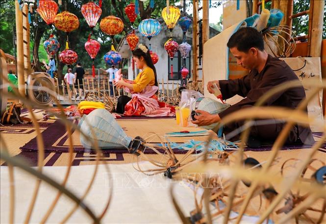  Nghệ nhân làm trực tiếp làm các sản phẩm lồng đèn. Ảnh: Khánh Hoà - TTXVN