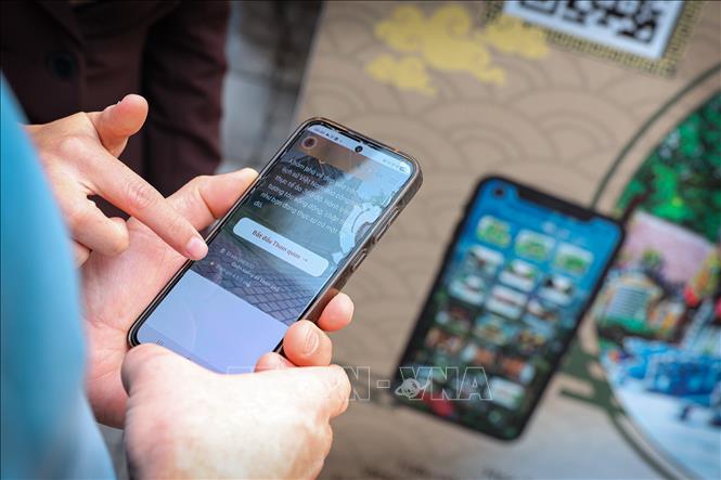 Du khách quốc tế trải nghiệm quét mã QR để tìm hiểu thông tin điểm đến, một điểm nhấn trong ứng dụng chuyển đổi số vào du lịch. Ảnh: Phạm Tuấn Anh - TTXVN