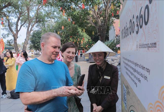 Du khách quốc tế trải nghiệm quét mã QR để tìm hiểu thông tin điểm đến, một điểm nhấn trong ứng dụng chuyển đổi số vào du lịch. Ảnh: Phan Phương - TTXVN