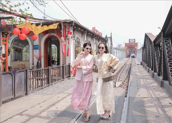 Du khách trong trang phục truyền thống lưu lại khoảnh khắc bên khu vực cầu Long Biên – điểm nhấn trong hành trình trải nghiệm Bet88013 88k Cho Tân Thủ Hà Nội trên “Tàu 5 cửa ô”. Ảnh: Phan Phương - TTXVN