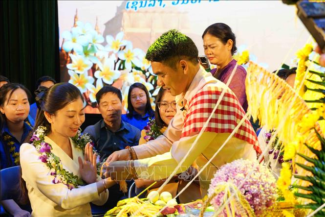 Nghi lễ buộc chỉ cổ tay tại chương trình. Ảnh: Nguyễn Cường - TTXVN. 
