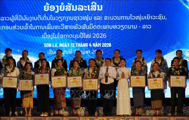 Lãnh đạo UBND tỉnh và lãnh đạo Tỉnh đoàn Sơn La tặng Bằng khen của Ban Thường vụ Tỉnh đoàn Sơn La cho các lưu học sinh Lào tiêu biểu đang học tập trên địa bàn có thành tích tốt trong học tập cũng như tham gia tích cực các hoạt động của tổ chức Đoàn, Hội. Ảnh: Nguyễn Cường - TTXVN 
