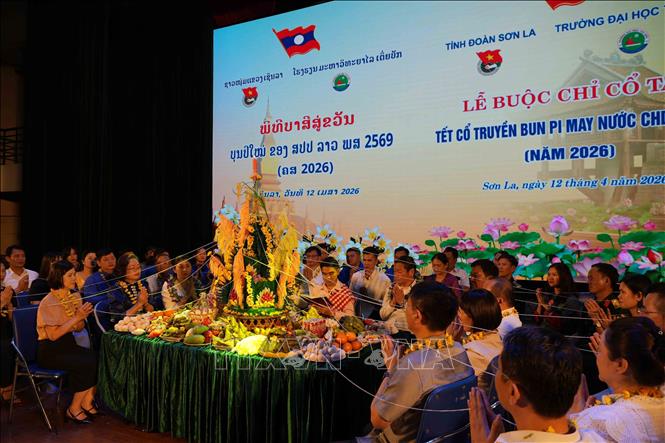 Nghi lễ buộc chỉ cổ tay tại chương trình. Ảnh: Nguyễn Cường - TTXVN. 
