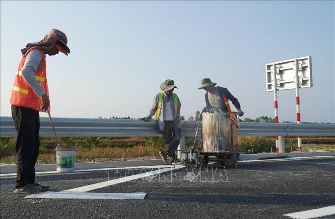 Nhân công thi công hạng mục an toàn giao thông trên tuyến cao tốc Hậu Giang - Cà Mau. Ảnh: Tuấn Phi - TTXVN