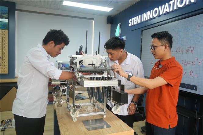 Học sinh Trường THPT Hàm Rồng trực tiếp tham gia các hoạt động như lập trình robot, mô phỏng 3D, thiết kế sản phẩm và thực hành thí nghiệm tại phòng học STEM của nhà trường. Ảnh: Khiếu Tư - TTXVN 
