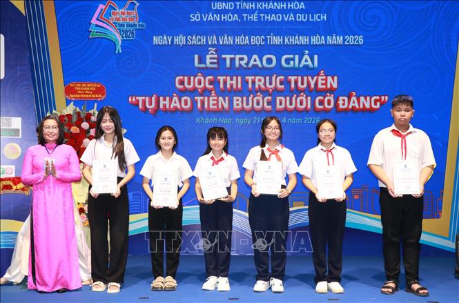 Đại diện Thư viện tỉnh Khánh Hòa trao giải Cuộc thi trực tuyến tìm hiểu với chủ đề: “Tự hào tiến bước dưới cờ Đảng” cho các học sinh đạt giải. Ảnh: Phan Sáu - TTXVN