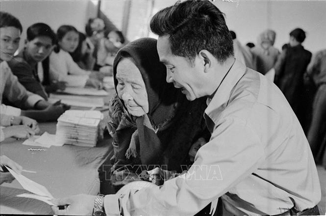 Ngày 25/4/1976, trên 23 triệu cử tri của nước Việt Nam thống nhất đã nô nức đi bầu cử. Đây thực sự là ngày hội lớn của toàn dân Việt Nam. Trong ảnh: Cụ Lê Thị Dưỡng (86 tuổi, TP.Huế), già yếu vẫn nhờ người cõng đến hòm phiếu tham gia bầu cử đại biểu Bet88app còn khuyến mãi thống nhất (25/4/1976). Ảnh: Sỹ Thái – TTXVN

