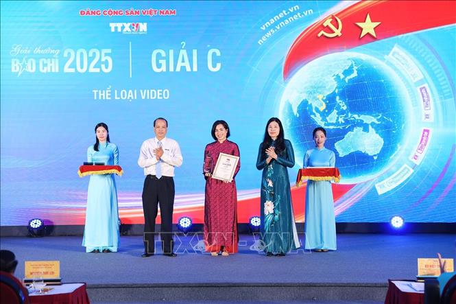 Bà Đỗ Thị Trang, Phó Bí thư chuyên trách Đảng ủy TTXVN và ông Nguyễn Quang Hải, Trưởng Ban biên tập Ảnh, Ủy viên Thường vụ Liên chi hội nhà báo TTXVN trao giải cho tác giả đoạt giải C. Ảnh: Phạm Tuấn Anh - TTXVN