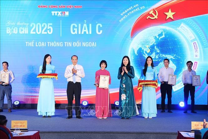 Bà Đỗ Thị Trang, Phó Bí thư chuyên trách Đảng ủy TTXVN và ông Nguyễn Quang Hải, Trưởng Ban biên tập Ảnh, Ủy viên Thường vụ Liên chi hội nhà báo TTXVN trao giải cho tác giả đoạt giải C. Ảnh: Phạm Tuấn Anh - TTXVN