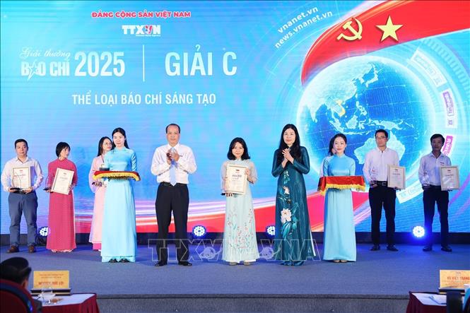 Nhà báo Nguyễn Quang Hải, Trưởng Ban biên tập Ảnh, Ủy viên Thường vụ Liên chi hội nhà báo và Bà Đỗ Thị Trang, Phó Bí thư chuyên trách Đảng ủy TTXVN trao giải C cho các tác giả. Ảnh: Phạm Tuấn Anh - TTXVN