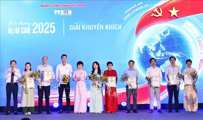 Nhà báo Ninh Hồng Nga, Tổng biên tập báo Tin tức và Dân tộc trao giải Khuyến khích cho các tác giả. Ảnh: Minh Đức – TTXVN