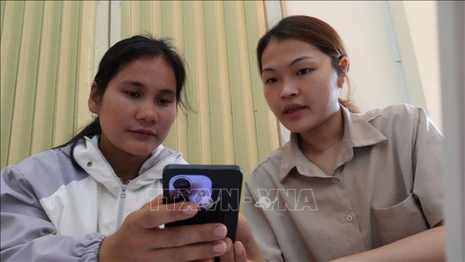 Thành viên Tổ công nghệ số cộng đồng xã Tu Mơ Rông hướng dẫn người dân nộp hồ sơ thủ tục hành chính trực tuyến. Ảnh: Dư Toán - TTXVN