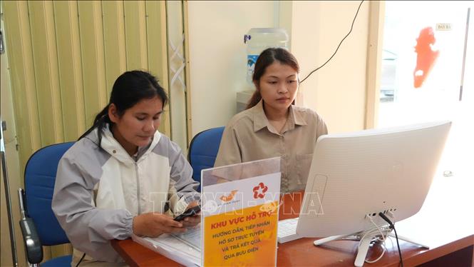 Thành viên Tổ công nghệ số cộng đồng xã Tu Mơ Rông hướng dẫn người dân nộp hồ sơ thủ tục hành chính trực tuyến. Ảnh: Dư Toán - TTXVN