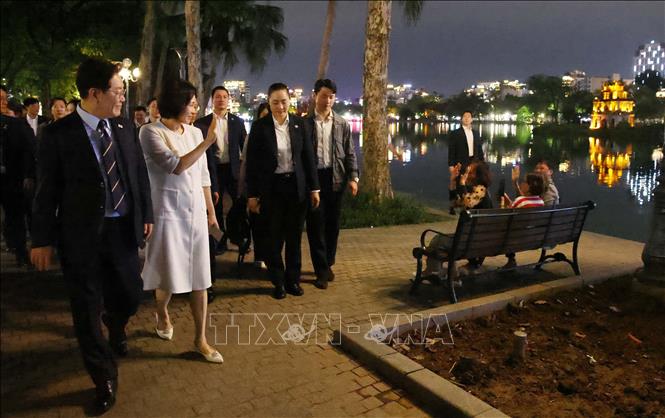 Tổng thống Hàn Quốc Lee Jae Myung và Phu nhân Kim Hae Kyung vẫy chào người dân Thủ đô bên hồ Hoàn Kiếm. Ảnh: Phạm Kiên - TTXVN