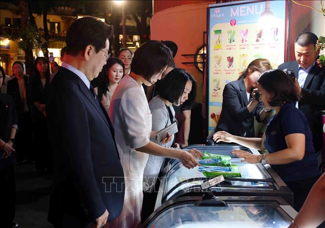 Tổng thống Hàn Quốc Lee Jae Myung và Phu nhân Kim Hae Kyung dừng chân mua kem Thủy Tạ tại khu vực hồ Hoàn Kiếm. Ảnh: Phạm Kiên - TTXVN