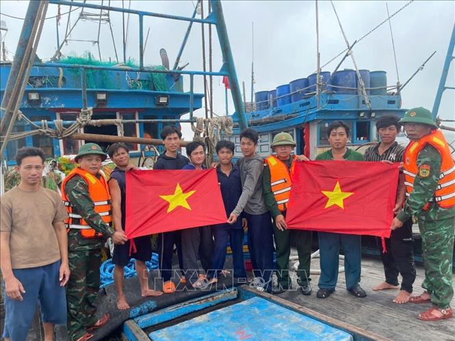 Đồn Biên phòng Roòn (Bộ đội Biên phòng tỉnh Quảng Trị) tặng cờ Tổ quốc cho ngư dân. Ảnh: Võ Dung - TTXVN