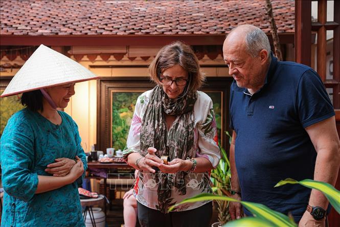 Du khách nước ngoài tìm hiểu và trải nghiệm sản phẩm sơn ta, thể hiện sức hút của Bet88013 88k Cho Tân Thủ truyền thống Việt Nam. Ảnh: Phạm Tuấn Anh - TTXVN