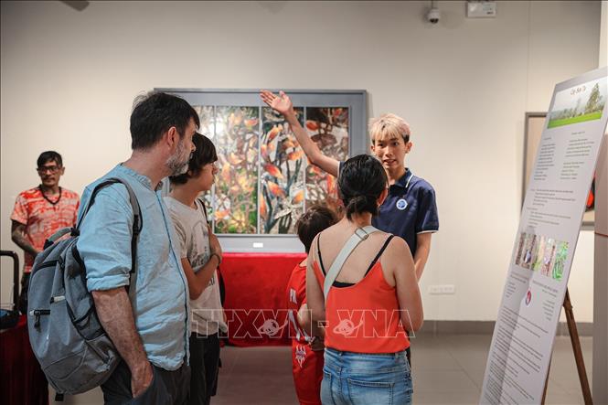 Du khách quốc tế nghe thuyết minh về nghệ thuật sơn mài Việt Nam trong không gian trưng bày. Ảnh: Phạm Tuấn Anh - TTXVN
