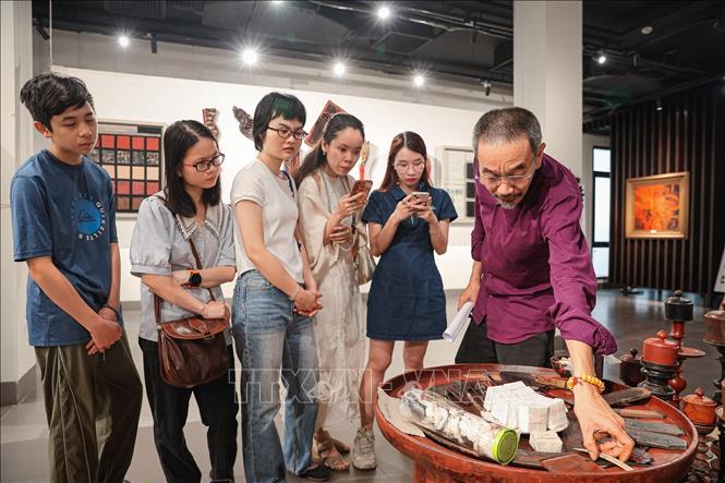 Nhà nghiên cứu Đàm Quang Minh giới thiệu về công dụng của những dụng cụ tới khách tham quan. Ảnh: Phạm Tuấn Anh - TTXVN
